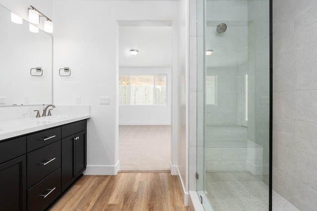 bathroom with vanity, wood-type flooring, and a tile shower