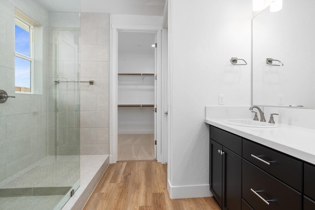 bathroom featuring vanity, hardwood / wood-style floors, and a tile shower