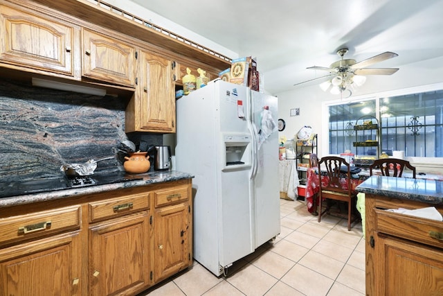 kitchen featuring light tile patterned floors, white refrigerator with ice dispenser, black electric stovetop, and ceiling fan