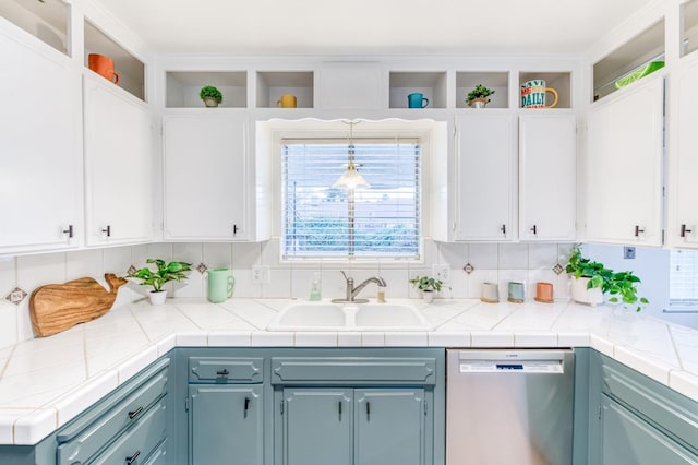 kitchen with tile countertops, decorative light fixtures, white cabinetry, dishwasher, and sink