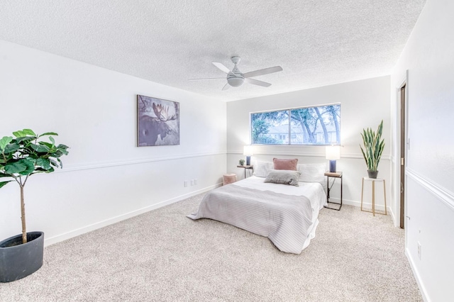 carpeted bedroom featuring ceiling fan and a textured ceiling