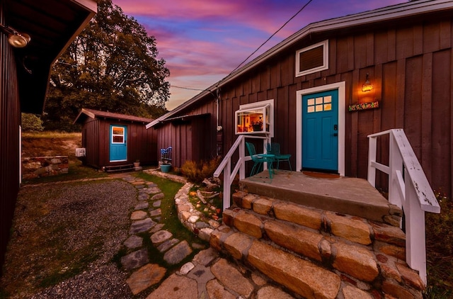 exterior entry at dusk featuring board and batten siding