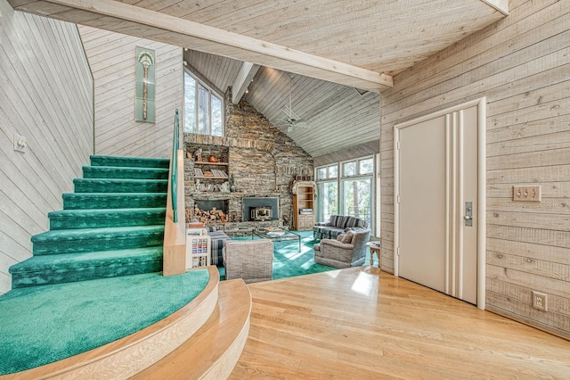 unfurnished living room with wood ceiling, light hardwood / wood-style flooring, high vaulted ceiling, beamed ceiling, and wood walls