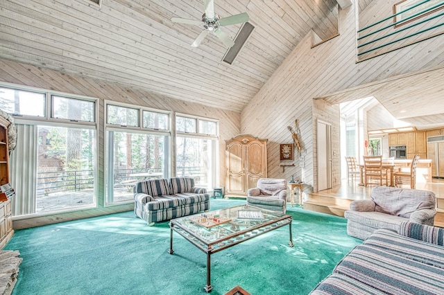 living room with high vaulted ceiling, wood walls, carpet, ceiling fan, and wooden ceiling