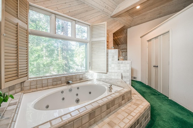 bathroom with beamed ceiling and tiled bath