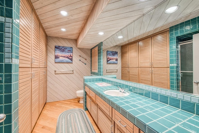 bathroom with wood ceiling, hardwood / wood-style floors, wood walls, toilet, and walk in shower