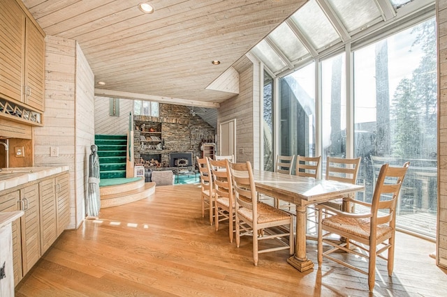 interior space featuring a stone fireplace and wooden ceiling