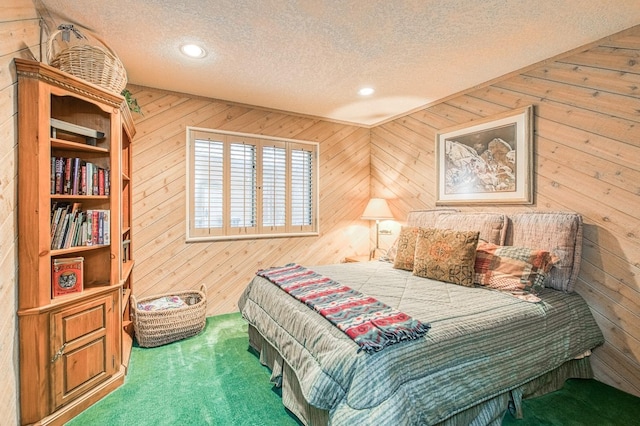 bedroom with carpet, a textured ceiling, and wood walls