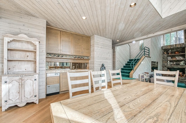 dining room featuring wooden ceiling, wooden walls, and light hardwood / wood-style floors