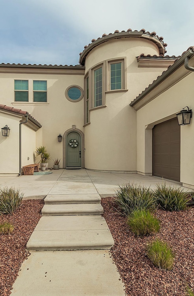 view of front of home featuring a garage and a patio area