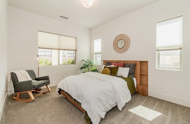 carpeted bedroom with visible vents and baseboards