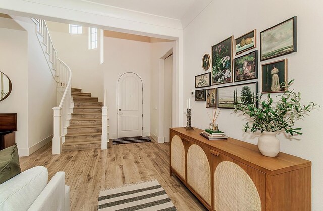 foyer with stairway, baseboards, and light wood-style floors