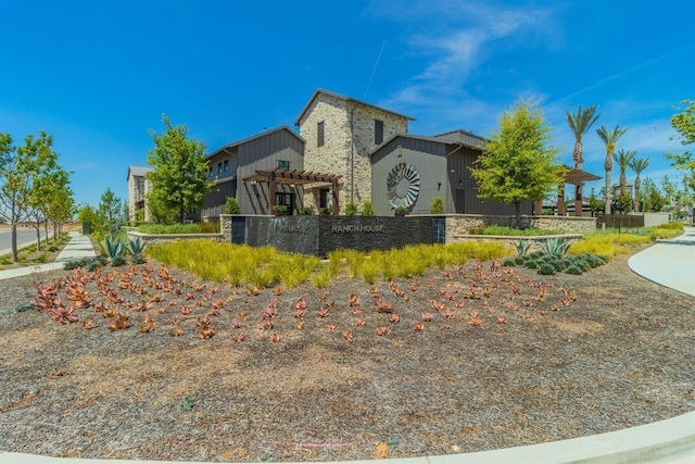 exterior space featuring stone siding and a pergola