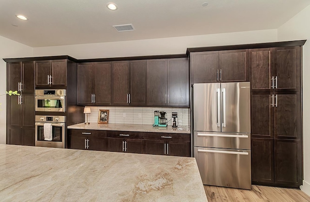 kitchen featuring decorative backsplash, light wood finished floors, visible vents, and appliances with stainless steel finishes