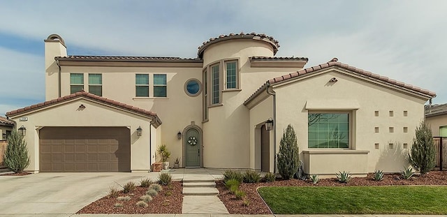 1009 Treasure Hills Dr, Madera, CA 93636 - mediterranean / spanish-style house with stucco siding, an attached garage, driveway, and a tiled roof