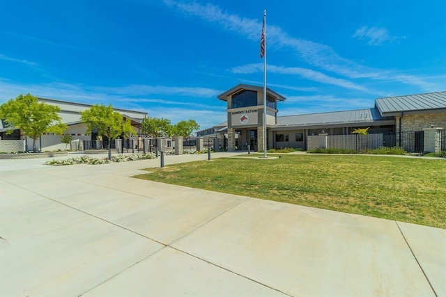 view of community featuring a lawn and fence