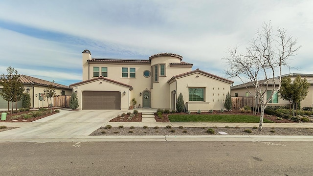 mediterranean / spanish-style home with fence, driveway, solar panels, an attached garage, and stucco siding