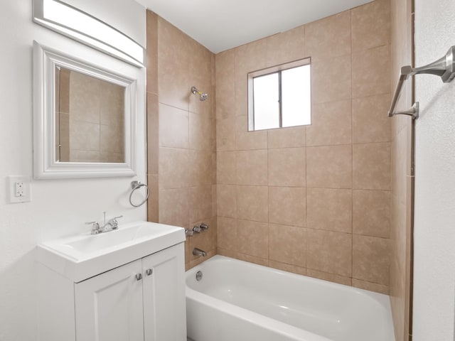 bathroom with tiled shower / bath combo and vanity