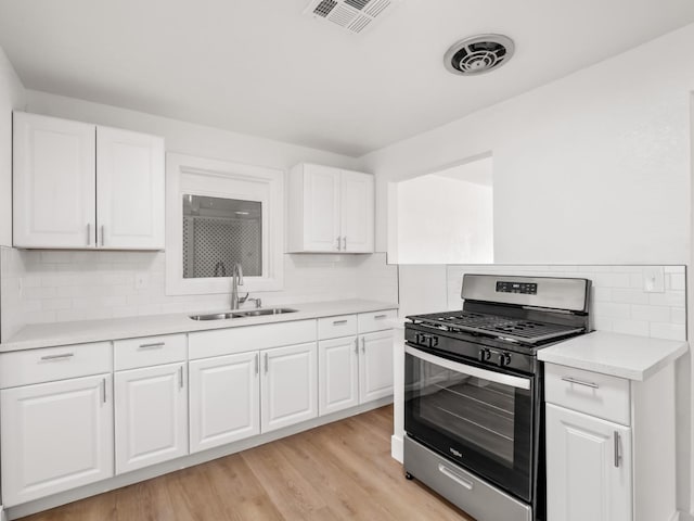 kitchen featuring white cabinetry, gas stove, sink, and light hardwood / wood-style floors