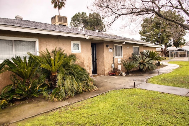 ranch-style house with a front yard and stucco siding