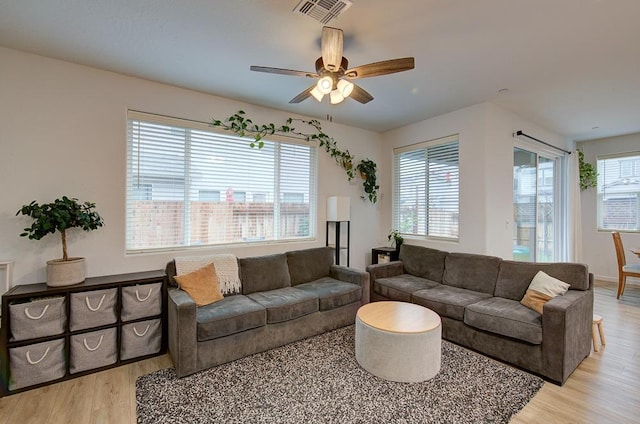 living room with light hardwood / wood-style flooring and ceiling fan