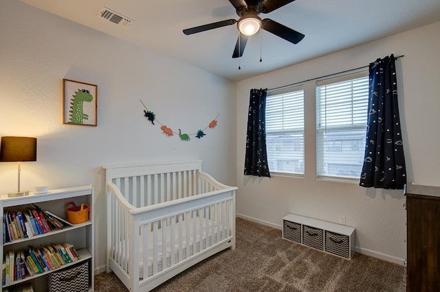 bedroom with carpet floors, a crib, and ceiling fan