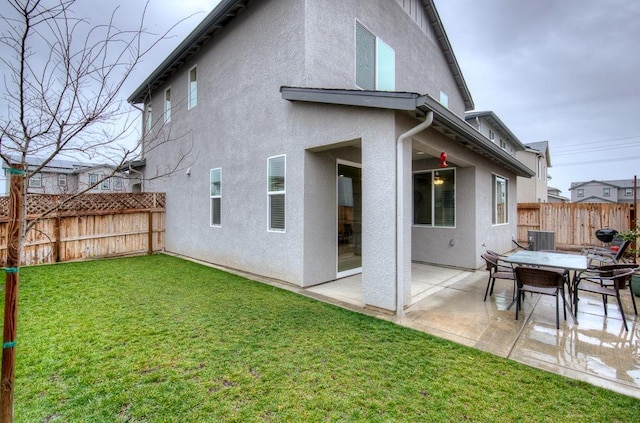 rear view of property with a yard, central AC unit, and a patio area