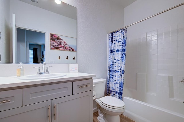 full bathroom featuring shower / bath combo, vanity, and toilet