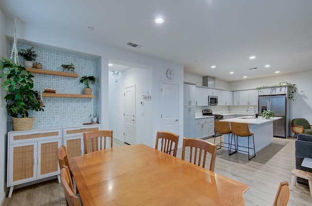 dining room featuring sink and light hardwood / wood-style floors