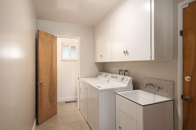 washroom with separate washer and dryer, light tile patterned floors, and cabinets