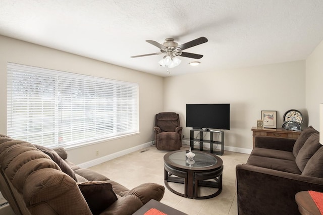 living room with light tile patterned floors, a textured ceiling, and ceiling fan