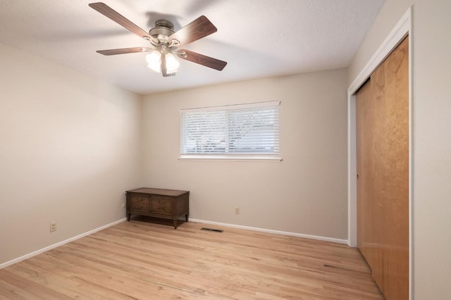 unfurnished bedroom featuring ceiling fan, a textured ceiling, light hardwood / wood-style floors, and a closet