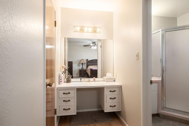 bathroom with ceiling fan, vanity, an enclosed shower, and wood-type flooring