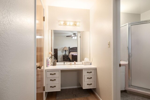 696 W Celeste Ave, Fresno, CA 93704 - ensuite bathroom featuring vanity, a stall shower, a ceiling fan, wood finished floors, and a textured wall