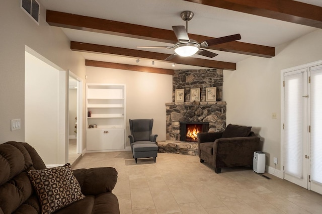 living room featuring ceiling fan, beam ceiling, a fireplace, light tile patterned flooring, and built in shelves