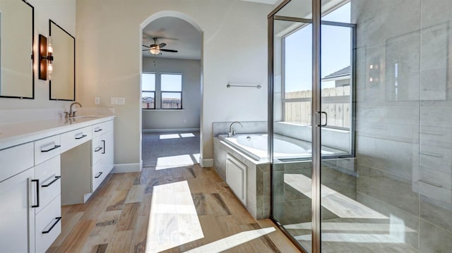 bathroom with independent shower and bath, vanity, wood-type flooring, and ceiling fan