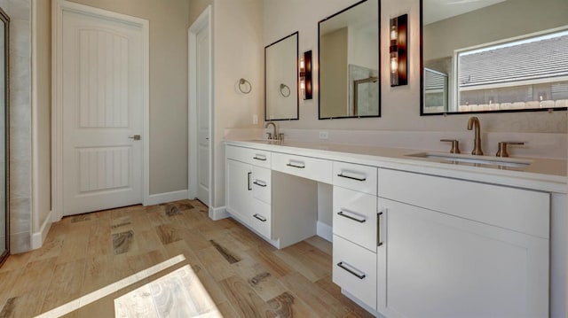 bathroom featuring hardwood / wood-style flooring, vanity, and walk in shower