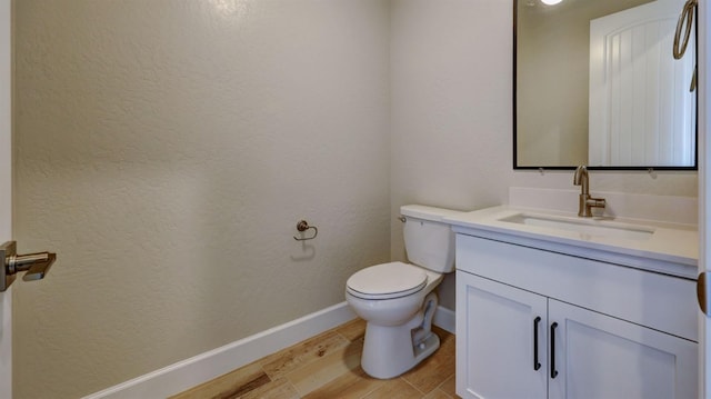 bathroom featuring vanity, wood-type flooring, and toilet