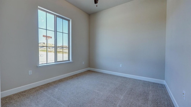 spare room with ceiling fan and carpet