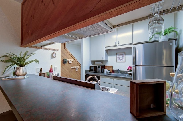 kitchen featuring sink, dishwasher, hanging light fixtures, white cabinets, and kitchen peninsula