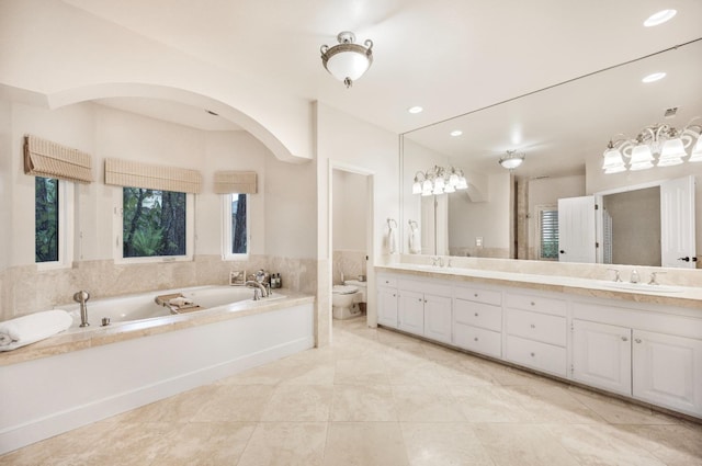 bathroom featuring vanity, a bath, tile patterned flooring, and toilet