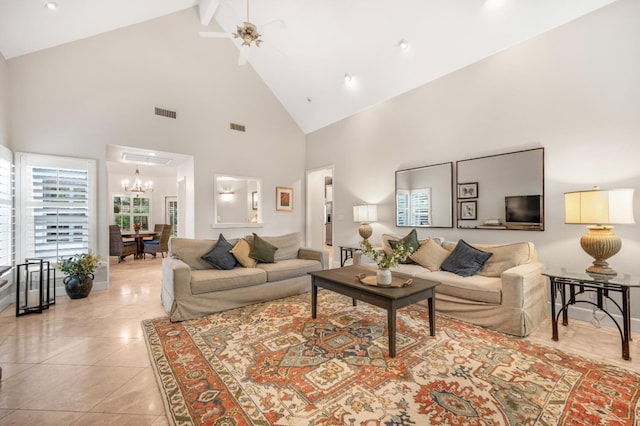 tiled living room with high vaulted ceiling, beam ceiling, and ceiling fan with notable chandelier