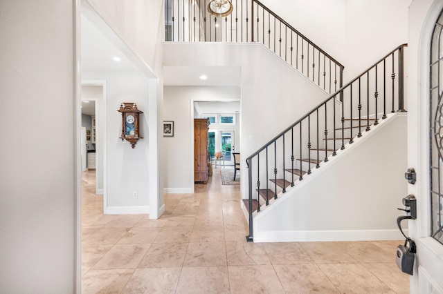 tiled foyer entrance with a towering ceiling