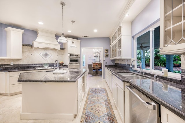 kitchen featuring sink, a center island with sink, stainless steel dishwasher, custom range hood, and pendant lighting