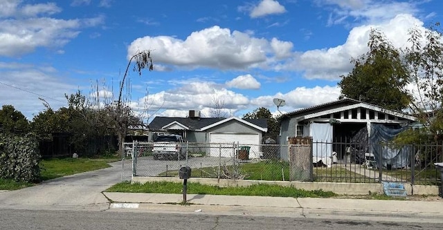 bungalow with a fenced front yard, a garage, and driveway