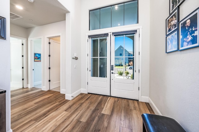 foyer featuring wood-type flooring and french doors