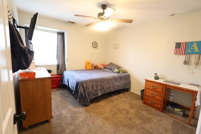 bedroom with ceiling fan and dark carpet