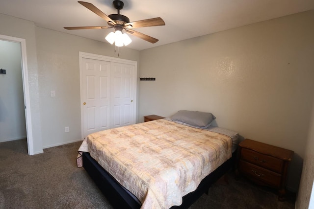 bedroom with ceiling fan, dark carpet, and a closet