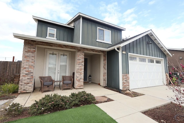 view of front of property with an attached garage, concrete driveway, board and batten siding, and brick siding