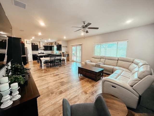 living room featuring light wood-style flooring, recessed lighting, visible vents, and a ceiling fan